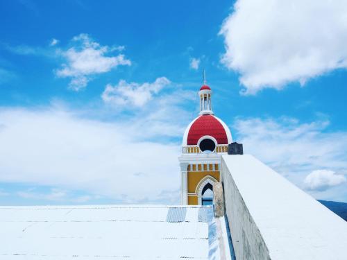 a red and white building with a red and white tower at Casa Marimba in La Laguna