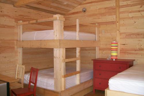 a bedroom with two bunk beds in a log cabin at Noah's Ark Campground in Revelstoke