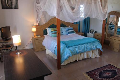 a bedroom with a bed with a canopy at Blue Lagoon Lodge Blantyre in Blantyre