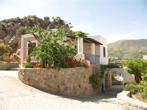 una casa con dei fiori su un muro di pietra di Villa Hermes Case Vacanza a Città di Lipari