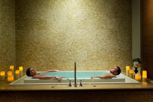 two men in a bath tub in a bathroom at Margaritaville Beach Resort South Padre Island in South Padre Island