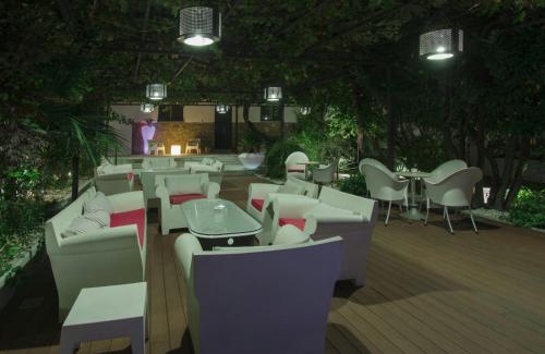 een restaurant met tafels en stoelen op een houten terras bij Hotel Rural Eloy in Baños de Montemayor
