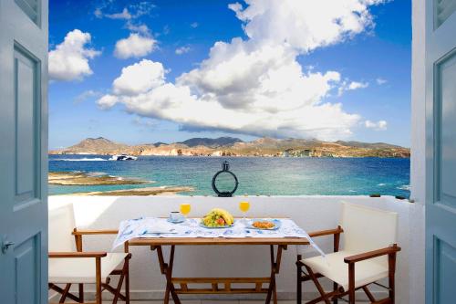 a table on a balcony with a view of the ocean at Venia's Guesthouse in Pollonia
