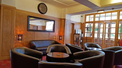 a waiting room with chairs and a clock on the wall at Medehamstede Hotel in Shanklin