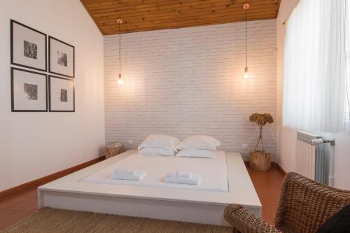 a bedroom with a white bed in a room at Herdade da Sanguinheira in Longomel