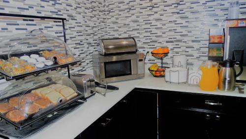 a kitchen with a counter with food and a microwave at Oak Tree Inn & Suites in Claxton