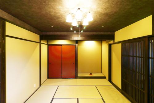 a hallway with a red door and a ceiling at Ryokan Karasawa in Kanazawa