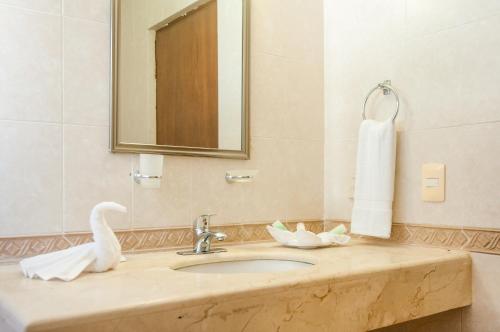 a bathroom with a sink with a mirror and a towel at Boutique House Cancun by Elevate Rooms in Cancún