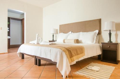 a bedroom with a large bed with white pillows at Boutique House Cancun by Elevate Rooms in Cancún