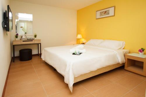 a hotel room with a white bed and a mirror at Hotel Sentral Kuala Terengganu in Kuala Terengganu