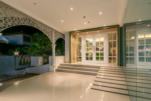 an external view of a building with glass doors at Yan's House Hotel in Kuta