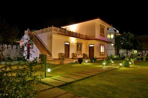 a house with lights in the yard at night at The Shergarh in Khilchipur