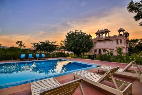 a swimming pool in front of a building at The Shergarh in Khilchipur