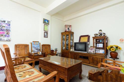 a living room with wooden furniture and a tv at Plum Inn 1 in Jiji