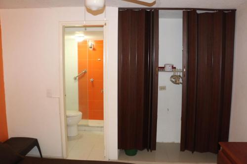 y baño con aseo y cortina de ducha. en Apartamento Palanoa 207 El Rodadero, en Santa Marta