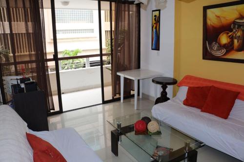 a room with two beds and a glass table at Apartamento Palanoa 207 El Rodadero in Santa Marta