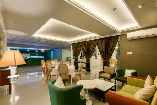 a waiting room with tables and chairs at Yan's House Hotel in Kuta