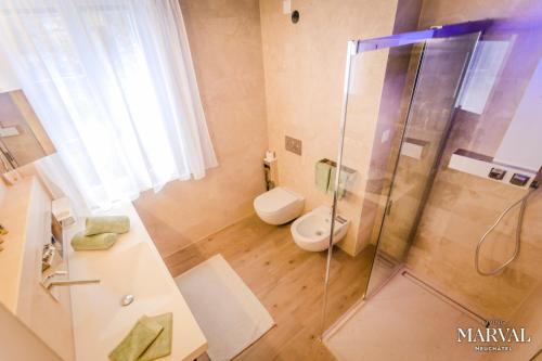 a bathroom with a toilet and a glass shower at Les Galeries Marval in Neuchâtel