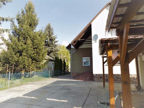 a house with a fence in front of a driveway at Éva Vendégház in Kaposvár