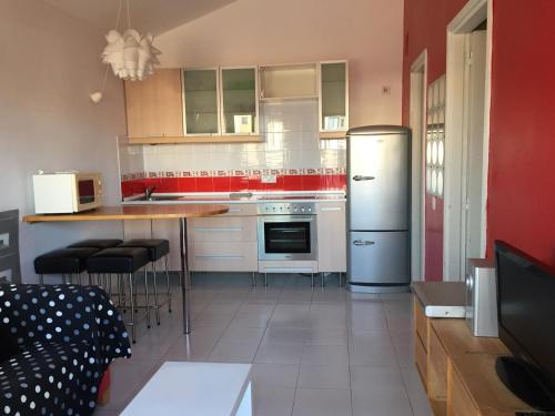 a kitchen with a refrigerator and a table in it at Cotillo Lagoons Apartment in El Cotillo