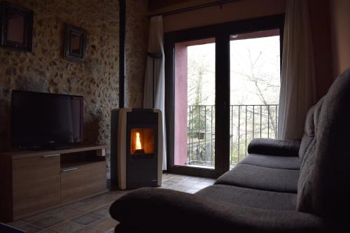 sala de estar con chimenea y TV en Ca La Tambona en Sant Felíu de Pallarols