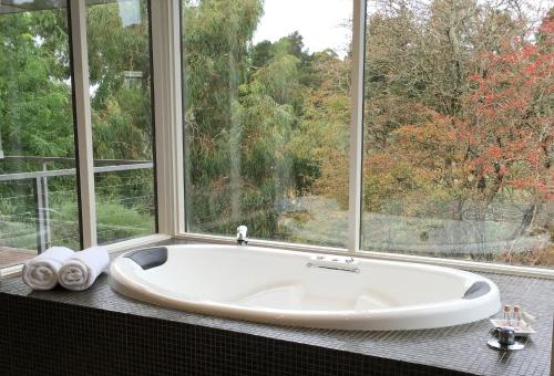 uma banheira na casa de banho com uma janela em Indulge at Daylesford em Daylesford