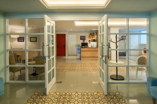 a room with glass doors with a plant in the middle at Yan's House Hotel in Kuta