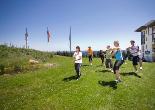 a group of people running on a grassy hill at Wellness-& Nationapark Hotel Schliffkopf, BWSC in Baiersbronn