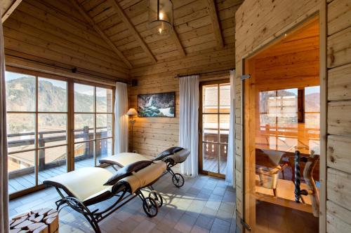 a room with chairs and windows in a cabin at Chaletdorf BERGHERZ in Sankt Johann im Pongau