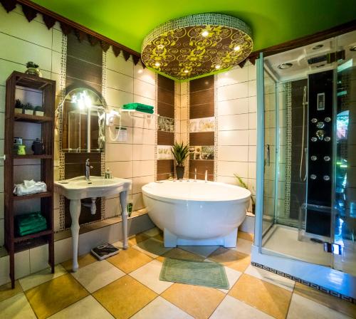 uma casa de banho com uma banheira grande e um lavatório em Fleur de vanille em Le Tampon