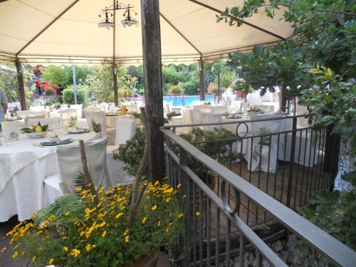 a restaurant with white tables and a white umbrella at Agriturismo La Casa Del Ghiro in Pimonte