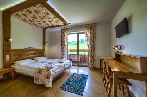 a bedroom with a bed and a large window at Montenero Resort&Spa in Czarna Góra