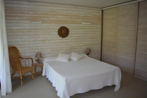 a bedroom with a white bed and a chair at Villa Argi Eder in Saint-Jean-de-Luz