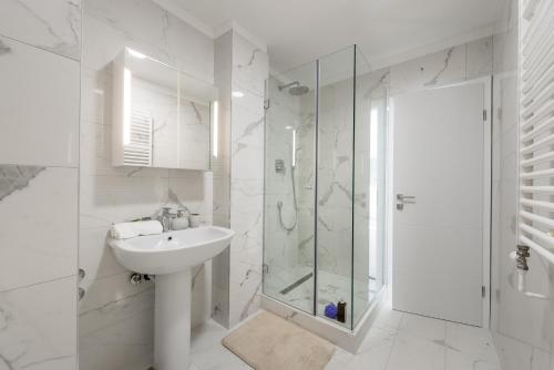 a white bathroom with a sink and a shower at Urban Chic LUXE apartments near Beach Bačvice & CENTRE in Split