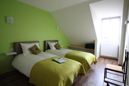 deux lits dans une chambre aux murs verts dans l'établissement Auberge de l'Arc en Ciel, à Fauquembergues