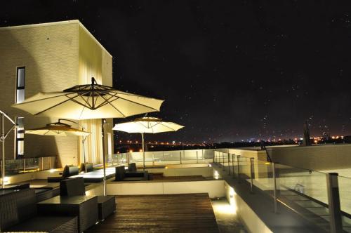a balcony with tables and umbrellas at night at Villa LOHERB in Dongshan