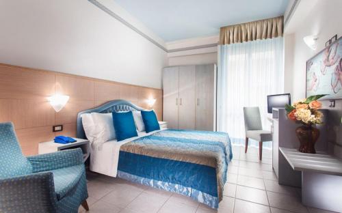 a hotel room with a bed and a chair at Hotel Imperiale in Milano Marittima