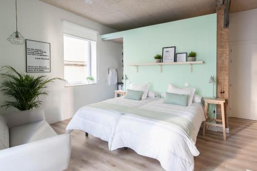 a bedroom with a large bed with white sheets at Urban Suite Santander in Santander