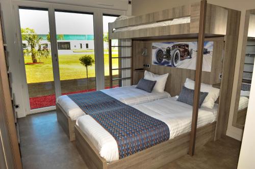 ein Schlafzimmer mit einem Bett und einem großen Fenster in der Unterkunft Résidence des Pilotes in Le Vigeant