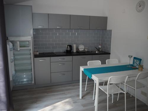a kitchen with a table and chairs and a refrigerator at Yacht Club Apartamenty in Radzyń