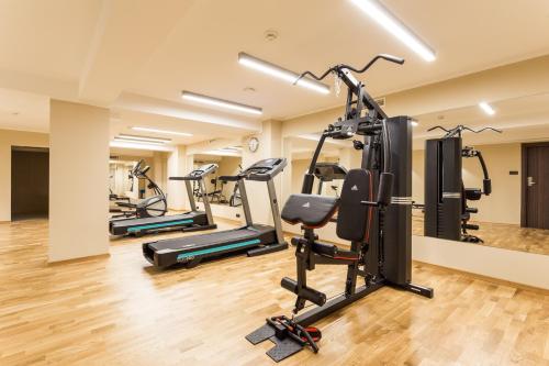 a gym with treadmills and ellipticals in a room at Hotel DeSilva Premium Poznań in Poznań