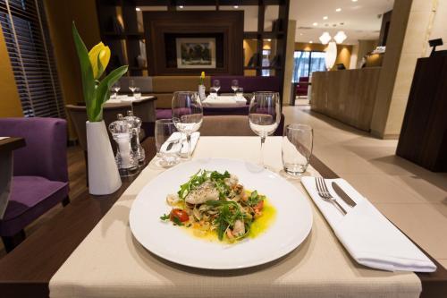 a plate of food on a table in a restaurant at Hotel DeSilva Premium Poznań in Poznań