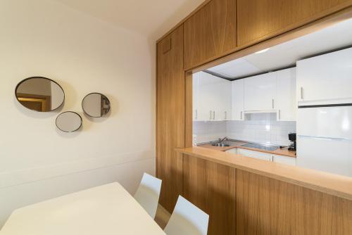 a kitchen with a table and chairs in a room at Apartamentos Costa Luz Punta Umbría in Punta Umbría