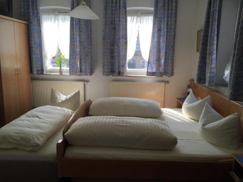 two beds in a bedroom with two pillows at Hotel Bezold in Rothenburg ob der Tauber
