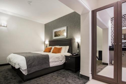 a hotel room with a bed and a mirror at BON Hotel Abuja in Abuja
