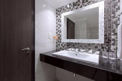 a bathroom with a sink and a mirror at BON Hotel Abuja in Abuja