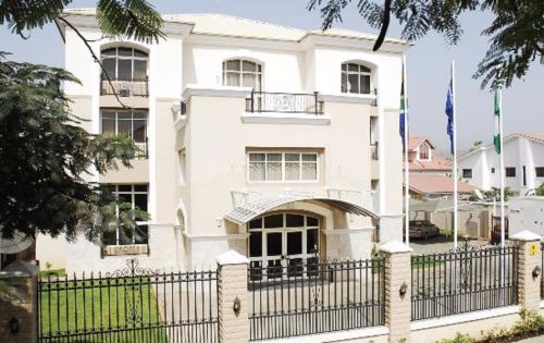 a white house with a black fence at BON Hotel Abuja in Abuja