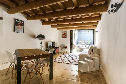un salon avec une table et des chaises en bois dans l'établissement Le Patio Carreterie - Maison chaleureuse avec Jacuzzi Extérieur Privatif - Primée pour sa déco, à Avignon