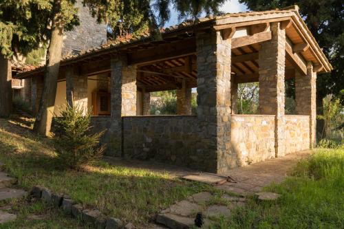 a stone house with a pavilion in a yard at Florence Country Relais in Fiesole