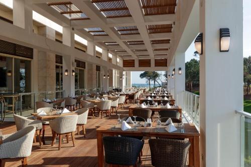 a restaurant with tables and chairs on a balcony at Rixos Premium Belek - The Land of Legends Access in Belek